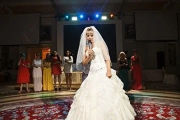 Невеста исполняет песню на торжестве.